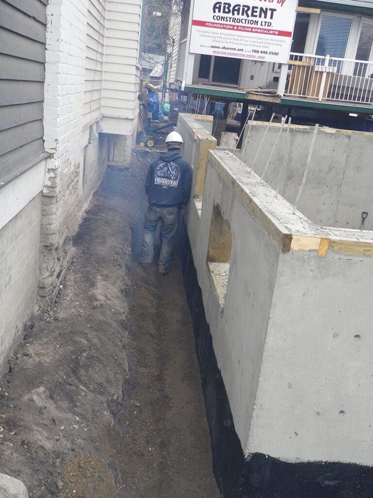 Professional foundation underpinning contractor examines structural support methods during building assessment