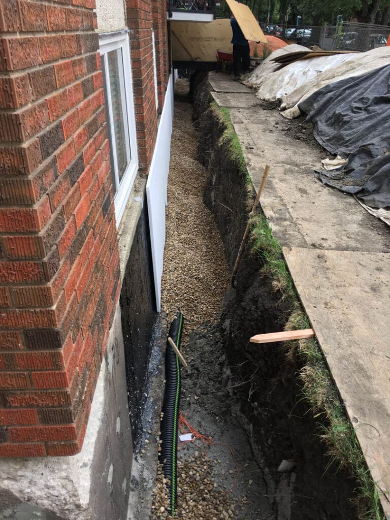 Professional contractor applies specialized foundation repair methods to damaged concrete foundation wall